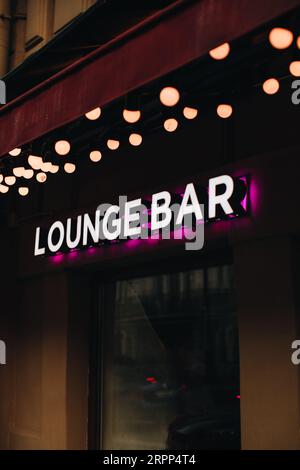 Neonschild auf schwarzem Hintergrund, Aufschrift Lounge Bar mit rosa Licht. Vertikal Stockfoto