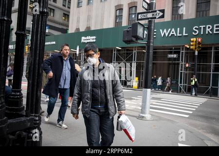 200312 -- NEW YORK, 12. März 2020 -- Ein Fußgänger, Der eine Gesichtsmaske trägt, spaziert am Broadway in der Nähe der New York Stock Exchange NYSE in New York, USA, 11. März 2020. Bis Mittwochabend gab es in den Vereinigten Staaten über 1.300 bestätigte Fälle und 38 Todesfälle, laut einem Tracking-Tool, das vom Center for Systems Science and Engineering an der Johns Hopkins University entwickelt wurde. Foto von /Xinhua U.S.-NEW YORK-COVID-19-BESTÄTIGTE FÄLLE MichaelxNagle PUBLICATIONxNOTxINxCHN Stockfoto