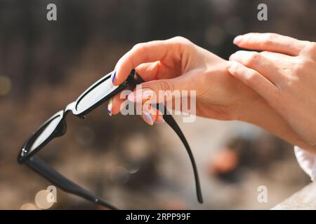 Stilvolle Sonnenbrille in weiblichen Händen Stockfoto