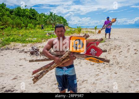 Panama, Archipielago de Bocas del Toro, am Strand von Cayos Zapatilla Männer laden die Bedarfsgegenstände auf ein Boot, das in einem Überlebensfernsehen benutzt wurde Stockfoto