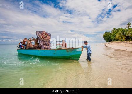 Panama, Archipielago de Bocas del Toro, am Strand von Cayos Zapatilla Männer laden die Bedarfsgegenstände auf ein Boot, das in einem Überlebensfernsehen benutzt wurde Stockfoto