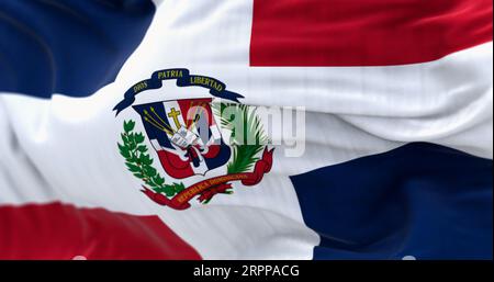 Nahaufnahme der wehenden Flagge der Dominikanischen Republik. Rote und blaue Flagge mit weißem Kreuz, Wappen in der Mitte. 3D-Illustrations-Rendering. Geriffeltes Material. Te Stockfoto