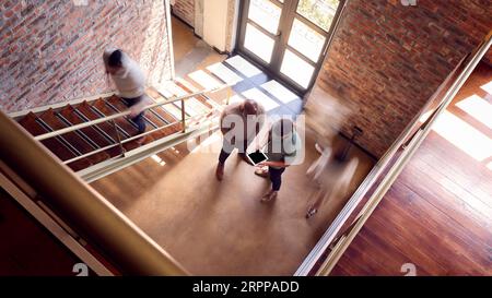 Zwei Männliche Geschäftskollegen Mit Digital Tablet Treffen Sich Im Geschäftigen Büro Informell Über Eine Treppe Stockfoto