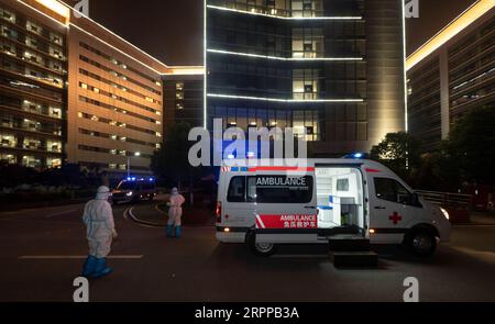 Coronavirus in China, Eindrücke aus Wuhan 200314 -- WUHAN, 14. März 2020 -- Teammitglied Yang Hui L und Wu Hongkun dehnen sich, während sie auf Patienten in Wuhan, Provinz Hubei in Zentralchina, warten, 13. März 2020. Während des Coronavirus-Ausbruchs kämpfen viele Transferteams an vorderster Front. Sie sind der Infektionsgefahr ausgesetzt und verkehren rund um die Uhr zwischen Krankenhäusern und medizinischen Behandlungsstationen, um sicherzustellen, dass die Patienten rechtzeitig an bestimmte Orte transportiert werden. Neun Mitglieder aus der Provinz Yunnan, nämlich Liu Jianyong, Huang Jie, Yang Hui, Yao Hongjun, Wu Hongkun, Liu Mengdi, Stockfoto