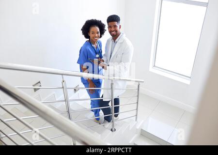 Porträt Des Männlichen Arztes Und Der Weiblichen Krankenschwester Mit Digitalem Tablet Auf Treppen Im Krankenhaus Stockfoto