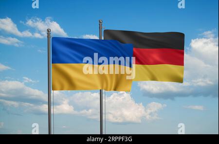 Deutsche Flagge und ukrainische Flagge, die am blauen Himmel zusammenwinken, zwei-Länder-Kooperationskonzept Stockfoto