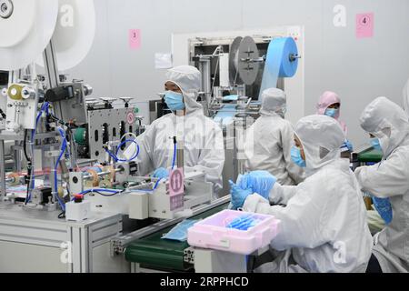 200318 -- SHENZHEN, 18. März 2020 -- Mitarbeiter stellen Masken in der Werkstatt zur Herstellung von Masken von Foxconn in Shenzhen, Provinz Guangdong in Südchina, 17. März 2020 her. In Shenzhen sind mehr als 97 Prozent der Industrieunternehmen über der ausgewiesenen Größe, und die wichtigsten Projekte werden wieder in Betrieb genommen. CHINA-GUANGDONG-SHENZHEN-WIEDERAUFNAHME DER PRODUKTION CN LIANGXXU PUBLICATIONXNOTXINXCHN Stockfoto