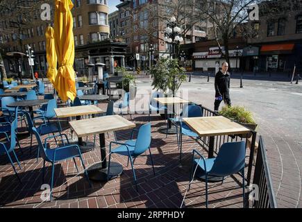 200318 -- VANCOUVER, 18. März 2020 Xinhua -- Ein Fußgänger passiert leere Plätze vor einem Restaurant in Vancouver, Kanada, 17. März 2020. Der kanadische Premierminister Justin Trudeau kündigte am Montagnachmittag eine Reihe neuer Maßnahmen zur weiteren Eindämmung der COVID-19-Ausbreitung in Kanada an. Mehr Einzelhandelsgeschäfte, Bars und Restaurants schlossen ihre Türen, als die COVID-19-Fälle in Kanada zunehmen. Die kanadische Regierung von British Columbia hatte Restaurants und Bars zum Schließen angeordnet, um Menschen von gesellschaftlichen Zusammenkünften fernzuhalten. Foto: Liang Sen/Xinhua CANADA-VANCOUVER-COVID-19 PUBLICATIONxNOTxINxCHN Stockfoto