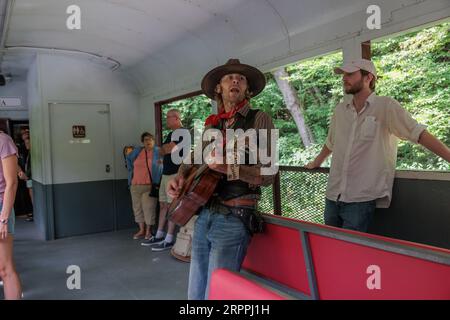 Sänger und Entertainer singen Lieder für die Passagiere für Tipps für den Ausflug mit der Great Smoky Mountains Railroad ab Bryson City, North Carolina Stockfoto