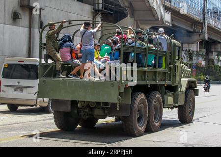 200318 -- MAKATI CITY, 18. März 2020 -- Menschen werden auf einem Militärwagen gesehen, der gestrandeten Passagieren kostenlose Fahrten anbietet, nachdem die philippinische Regierung die Aussetzung von öffentlichen Massenverkehrseinrichtungen gemäß der erweiterten Gemeinschaftsquarantäne in Makati City, den Philippinen, am 18. März 2020 angeordnet hatte. PHILIPPINEN-MAKATI STADT-STAAT DER NATIONALEN KATASTROPHE-COVID-19 ROUELLEXUMALI PUBLICATIONXNOTXINXCHN Stockfoto