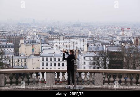 200318 -- PARIS, 18. März 2020 -- Eine Frau, die Maske trägt, macht Fotos während der Übungen im Montmartre in Paris, Frankreich, 18. März 2020. Der französische Präsident Emmanuel Macron hat am 16. März die bereits ergriffenen Maßnahmen zur Bekämpfung eines Sanitärkriegs gegen die COVID-19-Pandemie ausgeweitet, indem er Grenzschließungen, die Aussetzung des Flugverkehrs, strengere Verbringungsbeschränkungen und auch Strafen für Straftäter angeordnet hat. Ab Dienstagmittag und mindestens zwei Wochen lang können Menschen in französischen Städten nur aus Gründen der Arbeit, des Gesundheitsschutzes oder aus Gründen des Bedarfs ausziehen. FRANKREICH-PARIS-CORONAVIRUS-ALLTAG GAOXJING PUBLICA Stockfoto