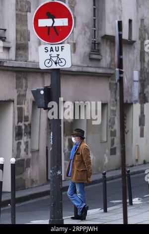 200318 -- PARIS, 18. März 2020 -- Ein Mann mit Maske steht auf der Straße in Paris, Frankreich, 18. März 2020. Der französische Präsident Emmanuel Macron hat am 16. März die bereits ergriffenen Maßnahmen zur Bekämpfung eines Sanitärkriegs gegen die COVID-19-Pandemie ausgeweitet, indem er Grenzschließungen, die Aussetzung des Flugverkehrs, strengere Verbringungsbeschränkungen und auch Strafen für Straftäter angeordnet hat. Ab Dienstagmittag und mindestens zwei Wochen lang können Menschen in französischen Städten nur aus Gründen der Arbeit, des Gesundheitsschutzes oder aus Gründen des Bedarfs ausziehen. FRANCE-PARIS-CORONAVIRUS-DAILY LIFE GaoxJing PUBLICATIONxNOTxINxCHN Stockfoto