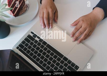 Draufsicht auf eine Frau, die einen Laptop während der Arbeit von zu Hause oder in einem modernen Büro verwendet. Stockfoto