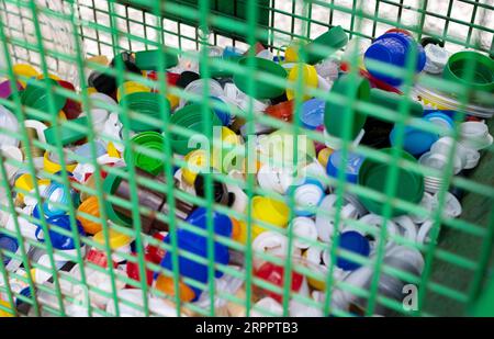 Städtischer Recyclingbehälter mit Kunststoffverschlüssen. Umwelt und globales Konzept Stockfoto