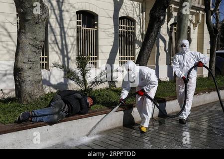 200322 -- ISTANBUL, 22. März 2020 -- Ein obdachloser älterer Mann ruht als Gemeindearbeiter, die Gesichtsmasken und Schutzanzüge tragen, die Desinfektion in Istanbul, Türkei, 21. März 2020 durchführen. Die Kommunalbehörden in der Türkei haben einige Bänke in Parks und Straßen entfernt, da viele ältere Menschen im Land trotz des Aufrufs der Regierung, drinnen zu bleiben, weiterhin in Parks, Geschäften und Basaren strömen. Die Türkei bestätigte bisher neun Todesfälle durch COVID-19, da die Gesamtzahl der bestätigten Fälle auf 670 stieg. Foto von Yasin Akgul/Xinhua TÜRKEI-ISTANBUL-ÄLTERE MENSCHEN XuxSuhui PUBLICATIONxNOTxINxCHN Stockfoto