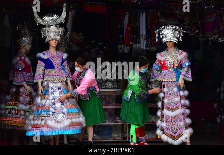 200323 -- RONGSHUI, 23. März 2020 -- Huang Yuping L zeigt Miao Kleidung in Rongshui Miao Autonomous County, südchinesische Guangxi Zhuang Autonomous Region, 13. März 2020. 2012 ging Huang Yuping nach Rongshui, um eine Miao Kostümwerkstatt einzurichten und armen Frauen zu helfen, zu Hause zu arbeiten. Rongshui Miao Autonomous County ist ein zutiefst verarmtes County in Guangxi und ein Schlüsselbezirk in der nationalen Armutsbekämpfung und Entwicklungsarbeit. Es ist auch ein bedeutender Arbeiterexportbezirk. Die Arbeit im Ausland ist für viele arme Familien der wichtigste Ansatz, ihr Einkommen zu erhöhen. In den letzten Jahren, mit der Vertiefung der po Stockfoto