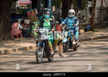 200323 -- VIENTIANE, 23. März 2020 -- Menschen, die Gesichtsmasken tragen, fahren mit Motorrädern auf der Straße in Vientiane, Laos, 23. März 2020. Die laotische Bevölkerung hat Präventivmaßnahmen gegen COVID-19 ergriffen, obwohl in Laos kein bestätigter Fall einer Virusinfektion vorliegt. Foto von Kaikeo Saiyasane/Xinhua LAOS-VIENTIANE-COVID19-DAILY LIFE ZhangxJianhua PUBLICATIONxNOTxINxCHN Stockfoto