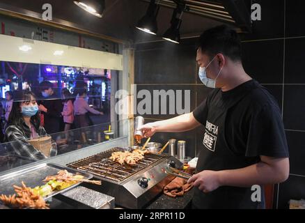 200324 -- CHONGQING, 24. März 2020 -- Ein Mitarbeiter röstet Fleisch in einem Grillrestaurant im Jiangbei-Bezirk von Chongqing, Südwestchina, 23. März 2020. Im Rahmen strenger Maßnahmen zur Bekämpfung der COVID-19-Pandemie hat Chongqing Bars, Restaurants und Snackverkäufer für die Bürger wieder geöffnet, um seine Nachtwirtschaft auf geordnete Weise anzukurbeln. CHINA-CHONGQING-COVID-19-NIGHT ECONOMY CN WANGXQUANCHAO PUBLICATIONXNOTXINXCHN Stockfoto