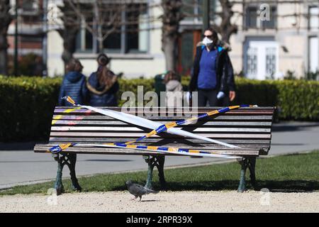 200325 -- BRÜSSEL, 25. März 2020 -- Eine Bank wird von der Polizei in einem Park in Brüssel, Belgien, am 25. März 2020, mit dem Absperrband gefesselt gesehen. Bänke in Parks wurden verboten, weil sie sitzen mussten, um zu verhindern, dass sich die Leute versammeln oder zu lange in den Parks bleiben. BELGIEN-BRÜSSEL-COVID-19-PARK-BANK ZhengxHuansong PUBLICATIONxNOTxINxCHN Stockfoto