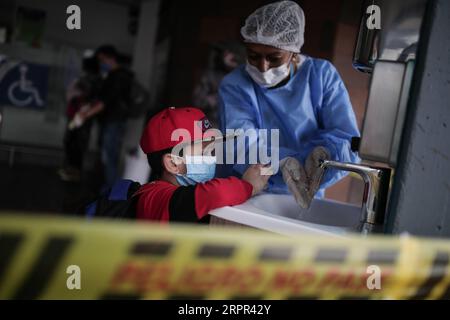 200326 -- BOGOTA, 26. März 2020 Xinhua -- Ein Mitarbeiter demonstriert, wie man einem Jungen an einem Busbahnhof in Bogota, Kolumbien, am 24. März 2020 die Hände wäscht. Die Länder Lateinamerikas haben am Mittwoch die Maßnahmen zur Eindämmung der COVID-19-Pandemie verschärft, da die Infektionsraten weiter gestiegen sind. Kolumbien, in dem 470 Fälle gemeldet wurden, hat bis zum 13. April eine landesweite Sperrung eingeleitet. Foto: Jhon Paz/Xinhua COLOMBIA-BOGOTA-COVID-19 PUBLICATIONxNOTxINxCHN Stockfoto