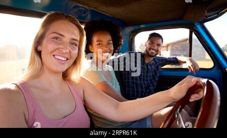 Porträt Einer Gruppe Von Freunden Auf Einem Roadtrip, Die Mit Dem Taxi Eines Pickup-Trucks Fahren Stockfoto