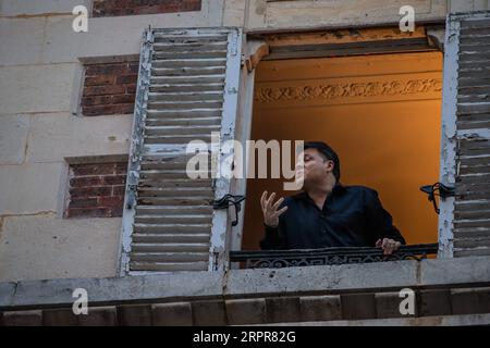 200329 -- PARIS, 29. März 2020 Xinhua -- der französische Tenor Stephane Senechal singt aus seinem Fenster für die Bewohner seiner Straße in Paris, Frankreich, 28. März 2020. Frankreich befindet sich in einem Lockdown, um die Ausbreitung der COVID-19-Pandemie einzudämmen. Foto von Aurelien Morissard/Xinhua FRANCE-PARIS-COVID-19-BALKON-MUSIKER PUBLICATIONxNOTxINxCHN Stockfoto