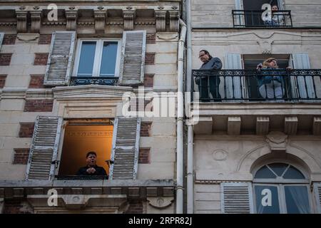 200329 -- PARIS, 29. März 2020 Xinhua -- der französische Tenor Stephane Senechal singt aus seinem Fenster für die Bewohner seiner Straße in Paris, Frankreich, 28. März 2020. Frankreich befindet sich in einem Lockdown, um die Ausbreitung der COVID-19-Pandemie einzudämmen. Foto von Aurelien Morissard/Xinhua FRANCE-PARIS-COVID-19-BALKON-MUSIKER PUBLICATIONxNOTxINxCHN Stockfoto