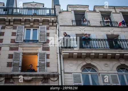 200329 -- PARIS, 29. März 2020 Xinhua -- der französische Tenor Stephane Senechal singt aus seinem Fenster für die Bewohner seiner Straße in Paris, Frankreich, 28. März 2020. Frankreich befindet sich in einem Lockdown, um die Ausbreitung der COVID-19-Pandemie einzudämmen. Foto von Aurelien Morissard/Xinhua FRANCE-PARIS-COVID-19-BALKON-MUSIKER PUBLICATIONxNOTxINxCHN Stockfoto