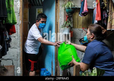 200330 -- QUEZON CITY, 30. März 2020 -- Ein Bewohner erhält eine Tüte Hilfsgüter während der Verteilung der Hilfe von der lokalen Regierung in einem Slum-Gebiet in Quezon City, Philippinen am 30. März 2020. PHILIPPINEN-COVID-19-RELIEF GOODS DISTRIBUTION ROUELLExUMALI PUBLICATIONxNOTxINxCHN Stockfoto