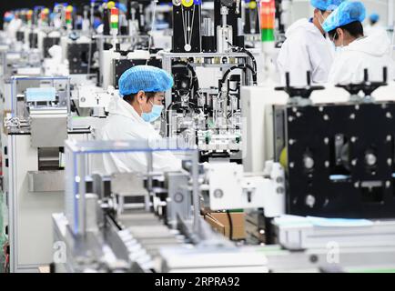 200330 -- TANGSHAN, 30. März 2020 -- Mitarbeiter arbeiten in einer Werkstatt zur Herstellung medizinischer Masken in Tangshan, nordchinesische Provinz Hebei, 30. März 2020. Ein von den lokalen Behörden zugelassenes Gerätehersteller in Tangshan hat ein Unternehmen zur Herstellung von Gesichtsmasken gegründet, um die Versorgung mit Gesichtsmasken im Kampf gegen die neuartige Coronavirus-Epidemie sicherzustellen. CHINA-HEBEI-TANGSHAN-COVID-19-FACIAL MASKS-PRODUCTION CN YANGXSHIYAO PUBLICATIONXNOTXINXCHN Stockfoto