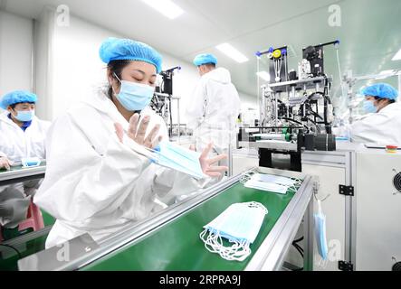 200330 -- TANGSHAN, 30. März 2020 -- Mitarbeiter arbeiten in einer Werkstatt zur Herstellung medizinischer Masken in Tangshan, nordchinesische Provinz Hebei, 30. März 2020. Ein von den lokalen Behörden zugelassenes Gerätehersteller in Tangshan hat ein Unternehmen zur Herstellung von Gesichtsmasken gegründet, um die Versorgung mit Gesichtsmasken im Kampf gegen die neuartige Coronavirus-Epidemie sicherzustellen. CHINA-HEBEI-TANGSHAN-COVID-19-FACIAL MASKS-PRODUCTION CN YANGXSHIYAO PUBLICATIONXNOTXINXCHN Stockfoto