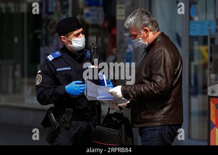 200331 -- BUKAREST, 31. März 2020 Xinhua -- Ein rumänischer Gendarm überprüft einen Mann auf Papiere bezüglich seiner Bewegungen in der Innenstadt von Bukarest, Rumänien, 30. März 2020. Rumänien kündigte eine landesweite Sperrung ab Mittwochmorgen an. Das Land trat am 16. März in den Ausnahmezustand ein, nachdem die Zahl der COVID-19-Fälle 100 überschritten hatte. Foto von Cristian Cristel/Xinhua ROMANIA-BUKAREST-COVID-19-CHECKING PUBLICATIONxNOTxINxCHN Stockfoto