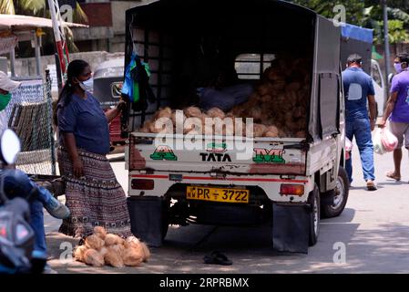 200331 -- COLOMBO, 31. März 2020 Xinhua -- Eine Frau, die eine Maske trägt, verkauft Kokosnüsse auf der Straße in Colombo, Sri Lanka, 30. März 2020. Sri Lanka hat bisher 122 COVID-19-Patienten bestätigt, von denen sich in den letzten Tagen 14 erholt und aus dem Krankenhaus entlassen haben, während 104 weitere in den ausgewiesenen Krankenhäusern im ganzen Land beobachtet werden. Das Land unterliegt weiterhin einer islandweiten Ausgangssperre, die am 20. März verhängt wurde, um die weitere Ausbreitung der Pandemie zu verhindern. Foto von Gayan Sameera/Xinhua SRI LANKA-COVID-19-CURFEW-LIFE PUBLICATIONxNOTxINxCHN Stockfoto