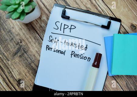 Konzept von SIPP - Selbstinvestierte persönliche Pension Schreiben Sie auf Papiere isoliert auf Holztisch. Stockfoto