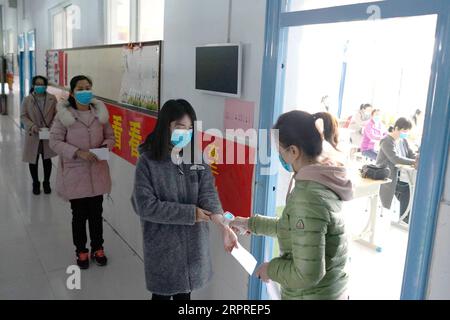 200402 -- XINGTAI, 2. April 2020 -- Lehrer, die als Schüler fungieren, nehmen Körpertemperaturkontrollen vor, bevor sie während einer Probe in einer Schule der Stadt Xingtai, Provinz Hebei, am 2. April 2020 in das Klassenzimmer gehen. Schulen in der Stadt Xingtai haben Proben für die Wiederaufnahme der Klasse von Schülern in ihrem letzten Jahr der Haupt- und Mittelschulen durchgeführt, um eine sichere und geordnete Schuleröffnung mit starren Maßnahmen zur Epidemieprävention zu gewährleisten. CHINA-HEBEI-XINGTAI-COVID-19-KLASSE RESUMPTION-REHEARSALCN MOUXYU PUBLICATIONXNOTXINXCHN Stockfoto