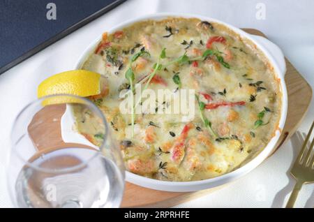 Gebackenes Lachsfilet in cremiger Sauce mit Gemüse, Fischpastete, Auflaufform mit käsigem Belag Stockfoto