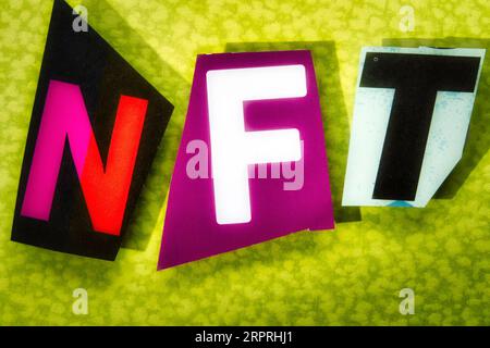 Das Akronym „NFT“ (Non-fungible Token) mit ausgeschnittenen Papierbuchstaben in der Ransom-Note-Effekt-Typografie, USA Stockfoto