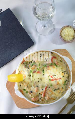 Gebackenes Lachsfilet in cremiger Sauce mit Gemüse, Fischpastete, Auflaufform mit käsigem Belag Stockfoto