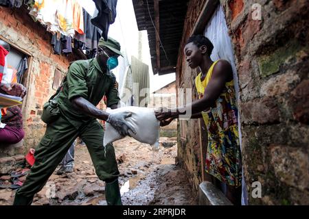 Bilder des Jahres 2020, News 04 April News Themen der Woche KW13 News Bilder des Tages 200404 -- KAMPALA, 4. April 2020 Xinhua -- Ein Offizier des Militärs übergibt einer Frau während der Nahrungsmittelhilfe in Kampala, der Hauptstadt Ugandas, am 4. April 2020. Uganda begann am Samstag mit der Nahrungsmittelversorgung von rund 1,5 Millionen städtischen Armen, die von der Sperrung betroffen sind, um den COVID-19-Ausbruch im Land einzudämmen. Foto: Hajarah Nalwadda/Xinhua UGANDA-KAMPALA-RELIEF FOOD DISTRIBUTION-COVID-19 PUBLICATIONxNOTxINxCHN Stockfoto