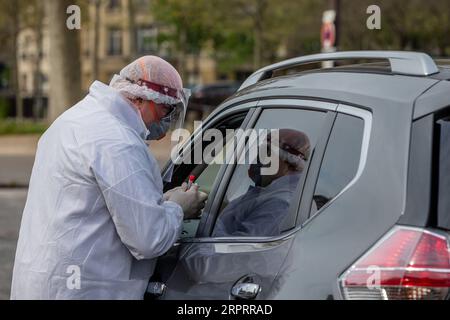 200407 -- PARIS, 7. April 2020 Xinhua -- Ein Biologe von Eylau Unilabs Analysis Laboratories sammelt eine Probe von einem Fahrer an einer COVID-19-Durchfahrtsteststation in der Nähe der Champs de Mars in Paris, Frankreich, 7. April 2020. Foto von Aurelien Morissard/Xinhua FRANCE-PARIS-COVID-19-DRIVE DURCH TEST PUBLICATIONxNOTxINxCHN Stockfoto