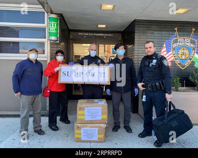 200407 -- NEW YORK, 7. April 2020 Xinhua -- Mitglieder der Beijing Association of New York und der Shandong Association of New York posieren mit Polizeibeamten, nachdem sie am 27. März 2020 5.000 Gesichtsmasken an die New Yorker Polizeibehörde 111 Precinct in New York, USA, geliefert hatten. Chinesische amerikanische Gemeinden in den Vereinigten Staaten Unternehmen große Anstrengungen, um Krankenhäusern, Polizeistationen und Anwohnern medizinische Versorgung zu spenden, um den Mangel zu verringern und zur Bekämpfung von COVID-19 im Land beizutragen. XINHUA USA-CHINA AMERICAN COMMUNITIES-FIGHT WITH COVID-19-MEDICAL SUPPLIES-DONATION PUBLICATIONXNOT Stockfoto