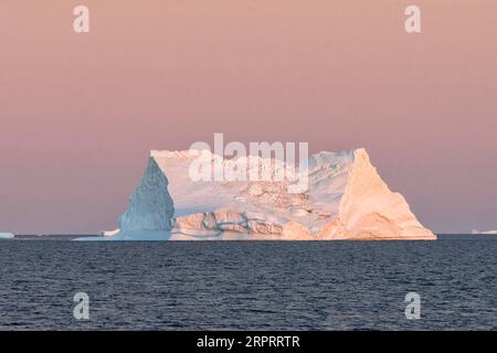 Riesiger schwimmender Eisberg in Disko Bay in der arktischen Morgendämmerung vor Sonnenaufgang. Disko Bay, Baffin Bay, Grönland, Dänemark, Europa Stockfoto