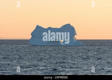 Riesiger schwimmender Eisberg in der Disko Bay in der arktischen Morgendämmerung kurz nach Sonnenaufgang. Disko Bay, Baffin Bay, Grönland, Dänemark, Europa Stockfoto