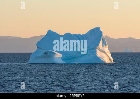 Riesiger schwimmender Eisberg in der Disko Bay in der arktischen Morgendämmerung kurz nach Sonnenaufgang. Disko Bay, Baffin Bay, Grönland, Dänemark, Europa Stockfoto