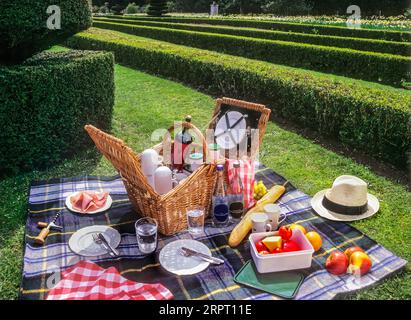 Picknickkorb und formeller Garten im Freien im Vereinigten Königreich, Speisen und Weine in einem englischen Landsitz im Sommer, England Großbritannien Stockfoto