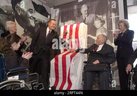 Der ehemalige Präsident George H.W. Bush, mit der ehemaligen First Lady Barbara Bush links, schüttelte mit dem Gründer der National Organization on Disability, Alan Reich, während der Veranstaltung im Franklin Delano Roosevelt Memorial, Washington, D.C., mit der Enthüllung der Widmungstafel für die Statue von Roosevelt im Rollstuhl Stockfoto