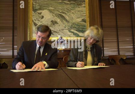 Utah Gouverneur Mike Leavitt, links, und Secretary Gale Norton unterzeichneten Memorandum of Understanding im Hauptquartier des Innenministeriums über die Anwendung des Gesetzes von 1866, das Wegerechte für eine mögliche Straßenentwicklung auf dem Bureau of Land Management Lands anerkennt Stockfoto