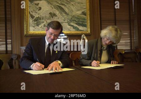 Utah Gouverneur Mike Leavitt, links, und Secretary Gale Norton unterzeichneten Memorandum of Understanding im Hauptquartier des Innenministeriums über die Anwendung des Gesetzes von 1866, das Wegerechte für eine mögliche Straßenentwicklung auf dem Bureau of Land Management Lands anerkennt Stockfoto