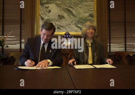 Utah Gouverneur Mike Leavitt, links, und Secretary Gale Norton unterzeichneten Memorandum of Understanding im Hauptquartier des Innenministeriums über die Anwendung des Gesetzes von 1866, das Wegerechte für eine mögliche Straßenentwicklung auf dem Bureau of Land Management Lands anerkennt Stockfoto