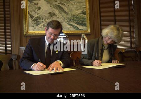 Utah Gouverneur Mike Leavitt, links, und Secretary Gale Norton unterzeichneten Memorandum of Understanding im Hauptquartier des Innenministeriums über die Anwendung des Gesetzes von 1866, das Wegerechte für eine mögliche Straßenentwicklung auf dem Bureau of Land Management Lands anerkennt Stockfoto